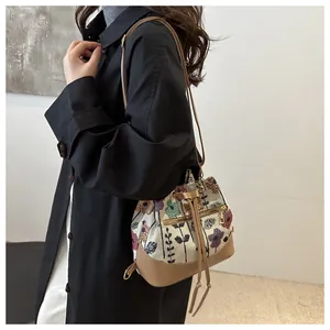 Floral drawstring bucket bag with cream fabric and brown leather strap detail shot