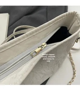 Détail de la fermeture éclair dorée fluide sur un sac seau à texture marbrée