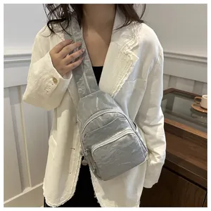 Close-up of silver-grey crinkle texture fabric on a stylish multi-zipper crossbody chest bag