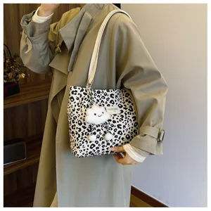 Detail of leopard print tote bag featuring a white cloud charm and branding label