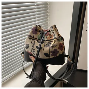 Close-up of vintage floral jacquard fabric and black leather drawstrings on bucket bag