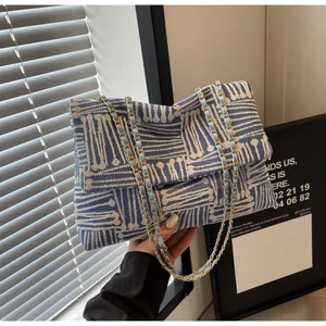 Detail of the blue and white woven jacquard fabric with chic gold metal chain strap