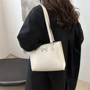 Large cream white tote bag with silver bow accent and minimalist shoulder strap design