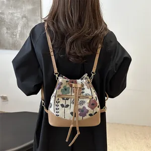 Floral jacquard bucket bag with khaki leather trim and adjustable drawstring closure