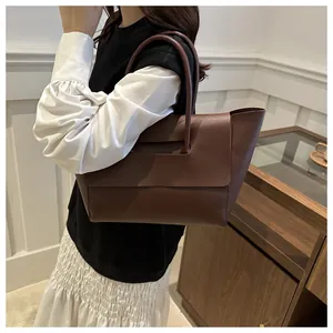Brown leather tote bag shown on a model for a stylish modern commuter look
