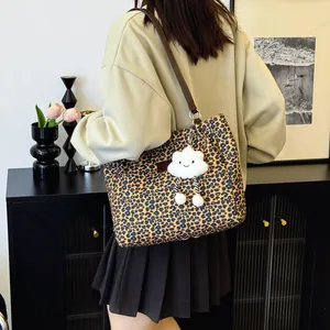 Leopard print tote bag with brown straps and white cloud charm shown on shoulder