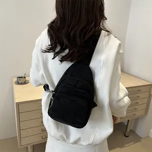 Minimalist black nylon crossbody sling bag with multi-layer zippers for women