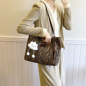 Chic leopard print tote bag with brown leather straps and cloud charm accessory