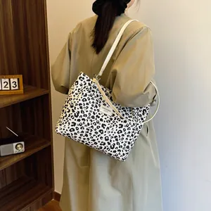 Retro leopard print tote bag with white leather straps shown on a model in trench coat