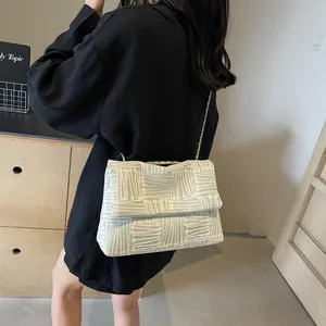 Light green mint crossbody bag with white geometric stripes and gold chain strap