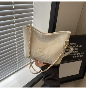 Vue détaillée du sac seau crème avec texture marbrée et bandoulière chaîne dorée