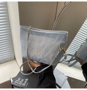 Détail du sac à bandoulière bleu clair avec texture froissée et chaîne dorée élégante