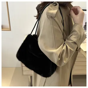 Detail einer weichen schwarzen Kunstpelz-Schultertasche mit dünnem Lederriemen am Model