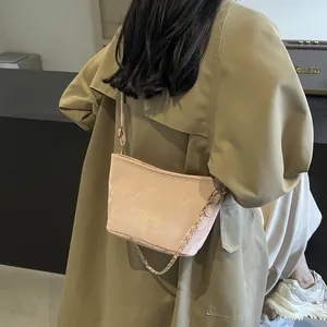 Sac seau plissé rose pour femme avec chaîne dorée porté sur l'épaule du modèle