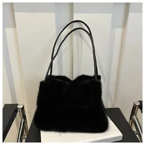 Detailaufnahme einer eleganten schwarzen Kunstfelltasche mit feinen Riemen auf weißem Sockel