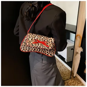 Detail view of leopard print shoulder bag with a red bow and thin red strap