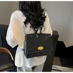 Detailed back view of a black retro oil wax leather backpack with gold oval logo