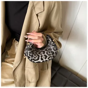 Detail der Crescent-Tasche mit Leopardenmuster, goldener Hardware und strukturierter Oberfläche