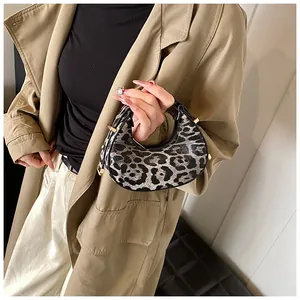 Detail der trendigen Halbmond-Tasche mit Leopardenmuster und goldener Hardware