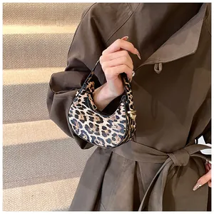 Detail der sichelförmigen Tasche mit Leopardenmuster und goldfarbenen Beschlägen