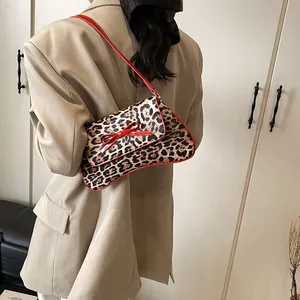 French leopard print square bag with red bow and shoulder strap on khaki blazer