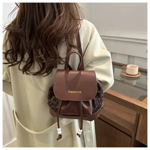 Detail eines braunen Vintage Mini-Rucksacks mit Leopardenmuster und goldener Aufschrift