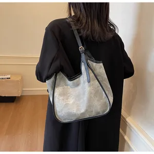 Grand sac fourre-tout gris avec texture rocheuse, lanières noires et boucles dorées