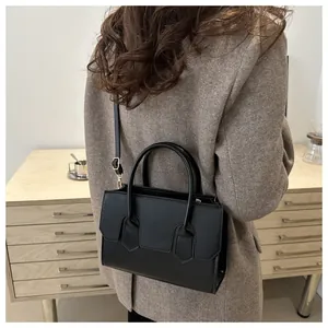 Modern black leather handbag worn with a brown blazer for an elegant office look