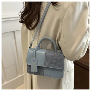 Detail der blau-grauen Patchwork-Leder-Schultertasche mit FASHION & BAGS Anhänger