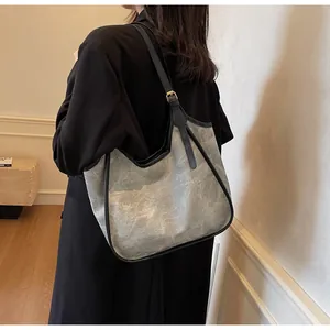 Détail du grand sac cabas en toile avec bandoulière réglable en cuir sur le mannequin