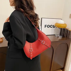 Rote Leder-Halbmondtasche unter dem Arm mit Vintage-Metallschnallen im Modestil 2024