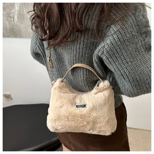 Detailaufnahme der beigen Kunstfell-Textur mit silbernem Sport-Metalllogo auf der Tasche