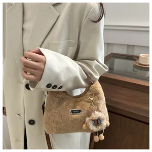 Makroaufnahme der flauschigen kamelfarbenen Kunstfell-Handtasche mit Sport-Logo und Bär