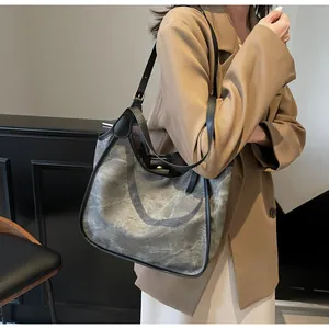 Grand sac fourre-tout texturé porté par un mannequin en blazer beige