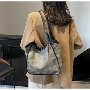 Grand sac cabas avec texture délavée grise et bordure en cuir noir porté par un mannequin