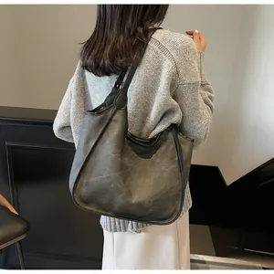 Grand sac cabas en cuir vieilli porté par un mannequin pour un style urbain chic
