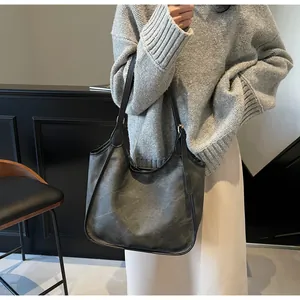 Grand sac cabas minimaliste avec liseré contrasté porté par un mannequin en tenue chic