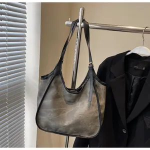 Détail du sac cabas gris fumé vintage avec bandoulières réglables en cuir noir sur cintre