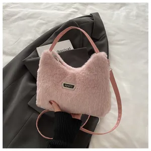 Detail der rosa Kunstfell-Tasche mit Metall-Sportplakette und weicher Textur