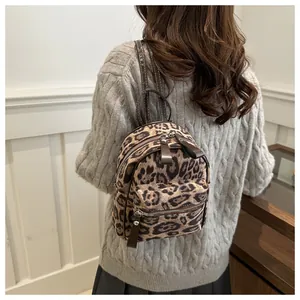 Detail eines trendigen Mini-Rucksacks mit Leopardenmuster und braunen Lederriemen