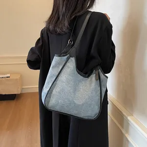 Grand sac cabas hobo en jean bleu avec finitions noires et bandoulière minimaliste