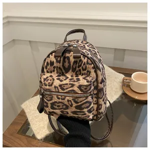 Detail eines trendigen Mini-Rucksacks mit Leopardenmuster, Vordertasche und braunen Ledergriffen