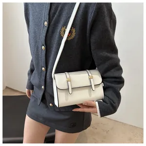 Zijaanzicht van een witte minimalistische crossbodytas gedragen door een model voor maat