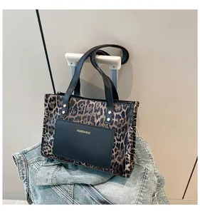 Detail of leopard print tote bag with gold lettering and faux leather texture