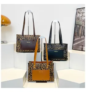 Three leopard print tote bags with colored pockets displayed on white studio pedestals