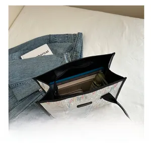 Interior view of large canvas tote bag showing tablet, notebook, and folding umbrella