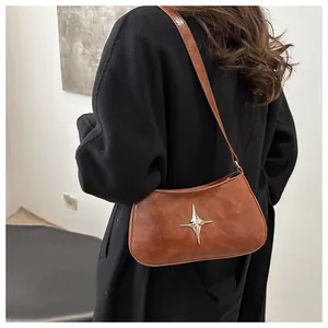 Sac croissant vintage marron avec détail étoile argentée porté par le mannequin