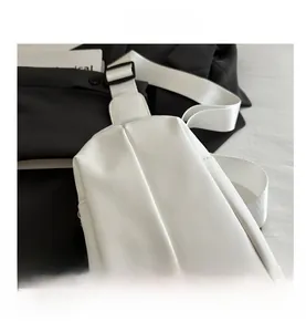 Detail view of white matte PU leather chest bag with vertical stitching and wide strap