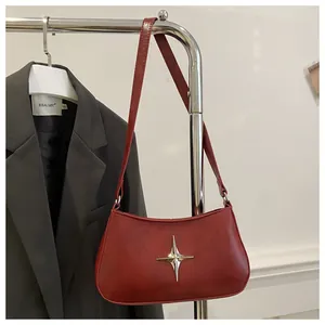 Gros plan du sac croissant rouge rétro avec étoile argentée sur un cintre en métal