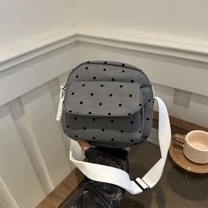 Mini grey polka dot canvas crossbody bag with wide adjustable shoulder strap and flap pocket